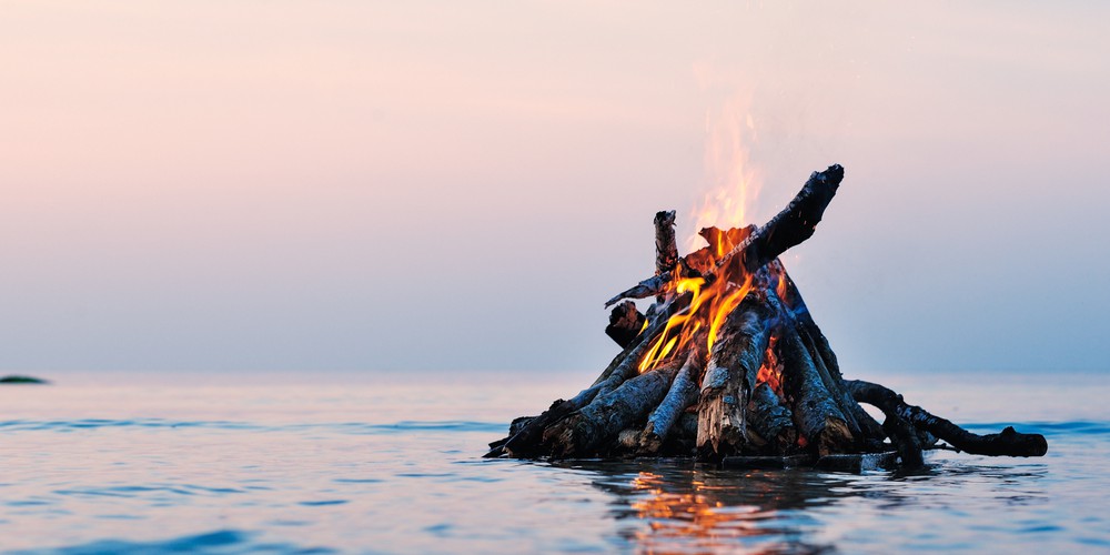 A bonfire surrounded by water